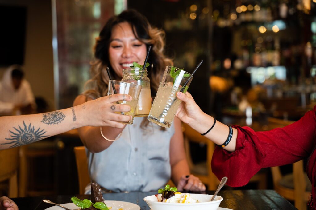 Photo of three women toasting at happy hour