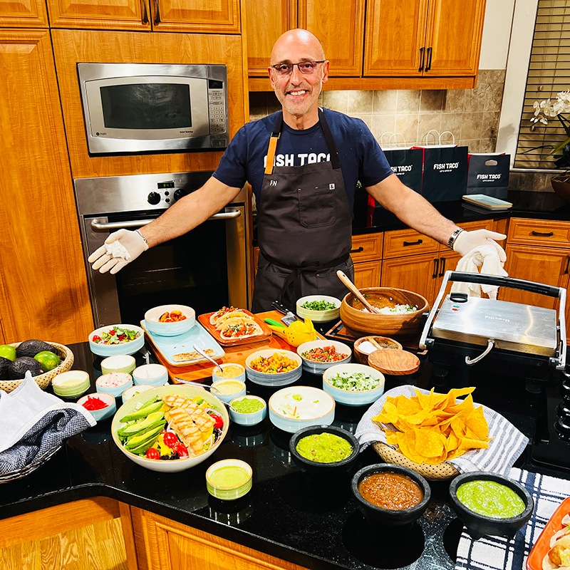 Owner of Fish Taco posing with a beautiful spread on Great Day Washington WUSA9