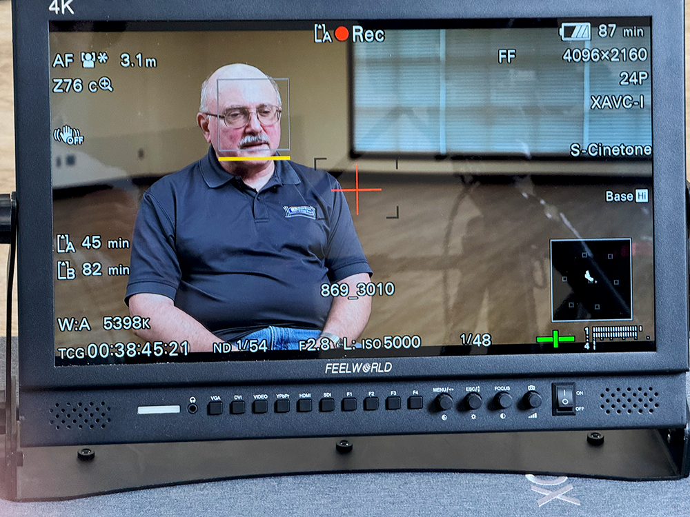 Up close look at the video field monitor of man in the interview.