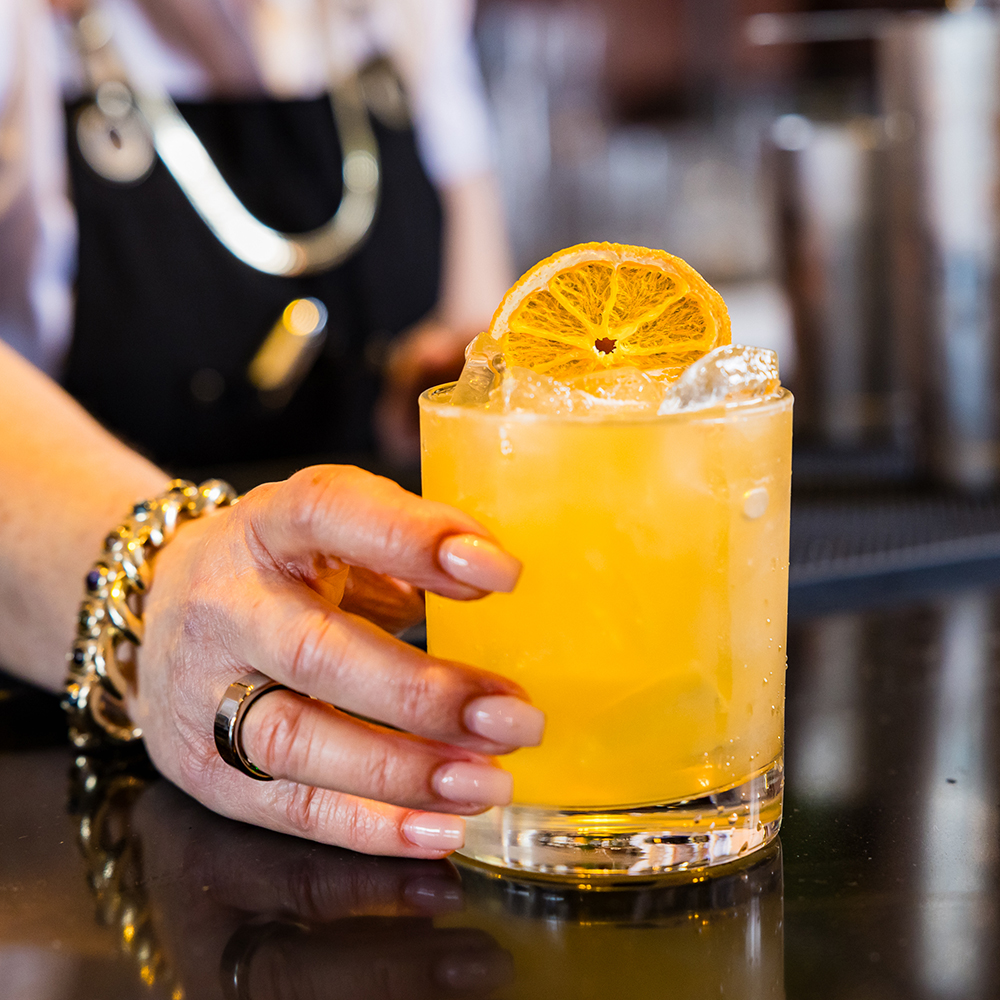 Close up of bartender hand holding cocktail
